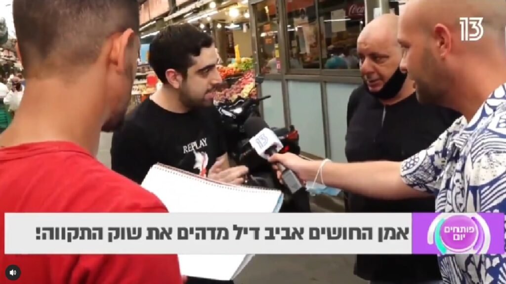 איש מדבר עם לקוחות בשוק, שני אנשים מקשיבים לו, אחד מהם מחזיק דף.